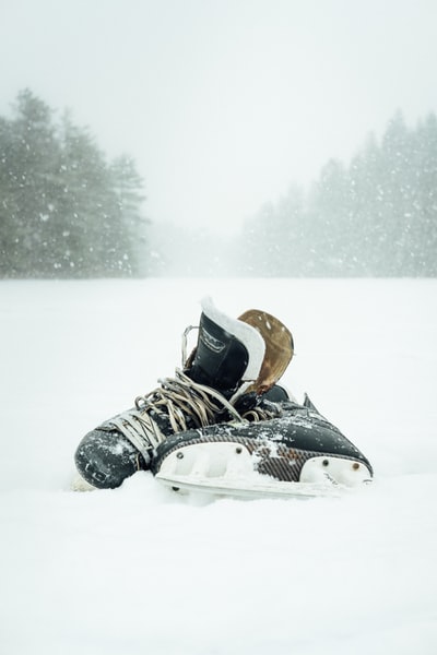 一双被雪包围的黑白溜冰鞋